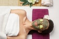 Cosmetologist smears cosmetic mask on the face of the woman in the spa salon. Spa clay mask on femele face.Skincare. Facial