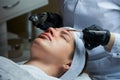 A cosmetologist uses a brush to apply a transparent face peeling to a woman Royalty Free Stock Photo