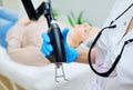 cosmetologist uses a CO2 fractional ablative laser to rejuvenate the skin and remove scars in a modern cosmetic beauty