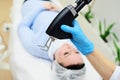 cosmetologist uses a CO2 fractional ablative laser to rejuvenate the skin and remove scars in a modern cosmetic beauty