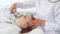 Cosmetologist uses iontophoresis for client`s face