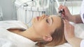 Cosmetologist uses iontophoresis for client`s forehead