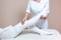 The cosmetologist wraps the leg of the customer. Anti-cellulite procedure