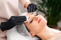 Cosmetologists doing facial massage and professional skin cleaning. Beautiful woman in spa salon getting face treatment Royalty Free Stock Photo