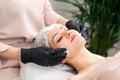 Cosmetologists doing facial massage and professional skin cleaning. Beautiful woman in spa salon getting face treatment Royalty Free Stock Photo