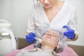 Cosmetology and acne treatment. Professional woman dermatologist in rubber gloves, applies the mask to the client& x27;s face Royalty Free Stock Photo