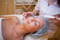 Cosmetology doctor makes woman treatments facial massage