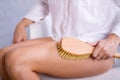 Cosmetology, grooming, Spa cosmetic products, beauty and bikini concept. closeup Woman in white makes massage legs with wooden sof