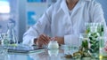 Cosmetology lab researcher testing new organic cream, modern tablet on table