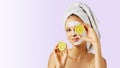 Cosmetology, skin care, face treatment, spa and natural beauty concept. Woman with facial mask holds lemons Royalty Free Stock Photo