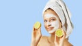 Cosmetology, skin care, face treatment, spa and natural beauty concept. Woman with facial mask holds lemons Royalty Free Stock Photo