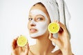 Cosmetology, skin care, face treatment, spa and natural beauty concept. Woman with facial mask holds lemons Royalty Free Stock Photo