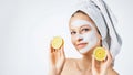 Cosmetology, skin care, face treatment, spa and natural beauty concept. Woman with facial mask holds lemons Royalty Free Stock Photo