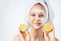 Cosmetology, skin care, face treatment, spa and natural beauty concept. Woman with facial mask holds lemons Royalty Free Stock Photo