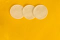 Cosmetology or skincare concept. Three white sponges to clean skin or makeup removing. Yellow blank background with group line