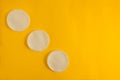 Cosmetology or skincare concept. Three white sponges to clean skin or makeup removing. Yellow blank background with group line