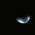 Cosmic blue half moon on starry dark background