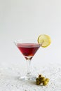 Cosmopolitan cocktail in the bar. martini glass of red cocktail with olives and lemon on white background. Royalty Free Stock Photo