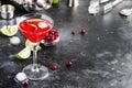 Cosmopolitan cocktail with vodka, liqueur, cranberry juice, lime, ice and orange zest, gray bar counter background, bartender Royalty Free Stock Photo