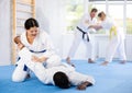 Cosmopolite sportsmen train of performing protection with wring hands during training in aikido