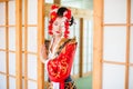 Cosplay. beautiful, modest geisha in a red kimono Royalty Free Stock Photo