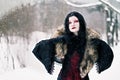 Cosplay black witch in winter forest