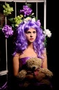 Cosplay girl in purple wig with toy and flowers