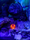 Cosplay of a stalker lying on the floor of an abandoned house in a plague doctor mask and holding a mysterious artifact