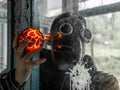 Cosplay of a stalker in a plague doctor mask holding a mysterious artifact and looking at it through glass. art photo