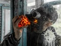 Cosplay of a stalker in a plague doctor mask holding a mysterious artifact and looking at it through glass. art photo