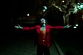 Cosplayer in the image of a clown walks at nigth city