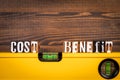 Cost and Benefits balance concept. Spirit level on a wooden background Royalty Free Stock Photo