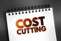 Cost Cutting - process used by companies to reduce their costs and increase their profits, text concept on notepad