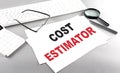 COST ESTIMATOR text on a paper with keyboard, calculator on grey background