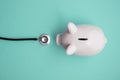 Cost of healthcare. Piggy bank money box with a medical doctors stethoscope Royalty Free Stock Photo