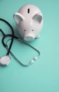 Cost of healthcare. Piggy bank money box with a medical doctors stethoscope Royalty Free Stock Photo