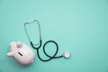 Cost of healthcare. Piggy bank money box with a medical doctors stethoscope Royalty Free Stock Photo