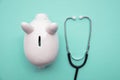 Cost of healthcare. Piggy bank money box with a medical doctors stethoscope Royalty Free Stock Photo