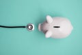 Cost of healthcare. Piggy bank money box with a medical doctors stethoscope Royalty Free Stock Photo