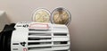 The cost of heating and electricity in Europe. Heating radiator thermostat with two coins of two euros on it