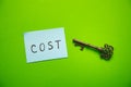 Cost word on sticky note with a old key Royalty Free Stock Photo