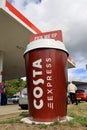 Large plastic Costa Coffee cup standing at a Esso petrol station. Royalty Free Stock Photo