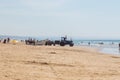 Costa da Caparica, Portugal - September 10, 2020: An artel of fishermen trawls fish from the tourist beach using a tractors.