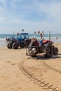 Costa da Caparica, Portugal - September 10, 2020: An artel of fishermen trawls fish from the tourist beach using a tractors.