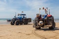 Costa da Caparica, Portugal - September 10, 2020: An artel of fishermen trawls fish from the tourist beach using a tractors.