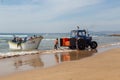 Costa da Caparica, Portugal - September 10, 2020: An artel of fishermen trawls fish from the tourist beach using a tractors.