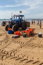 Costa da Caparica, Portugal - September 10, 2020: An artel of fishermen trawls fish from the tourist beach using a tractors.