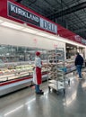 Costco deli employee restocking the deli platters