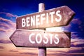 Costs, benefits - wooden signpost, roadsign with two arrows Royalty Free Stock Photo