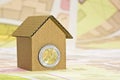 Costs about buildinh activity - Housing concept with cardboard house, euro coins and imaginary cadastral map